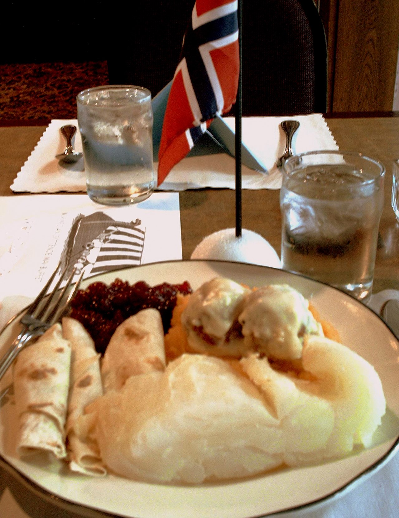 A syttende mai dinner in the Three Crowns Dining Room at Holiday Inn South, Rochester, Minnesota. Plate holds lutefisk, rutabaga, meatballs, lingonberries, and lefse. Photo: Jonathunder / Wikimedia CC.