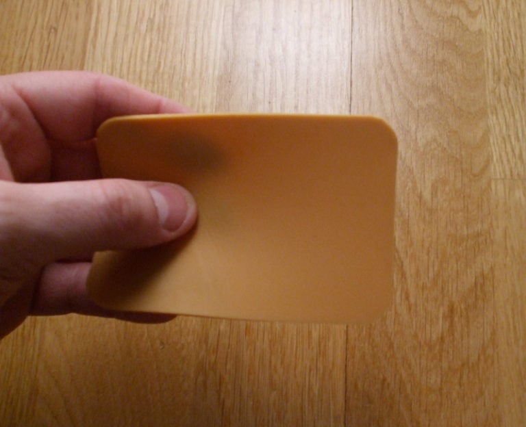 Slice of brown cheese compared to a wooden floor. Photo: David Nikel.