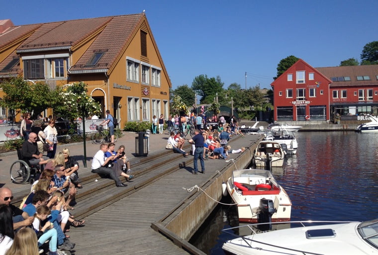 People relaxing at Kristiansand's Fiskebrygga in the sunshine.