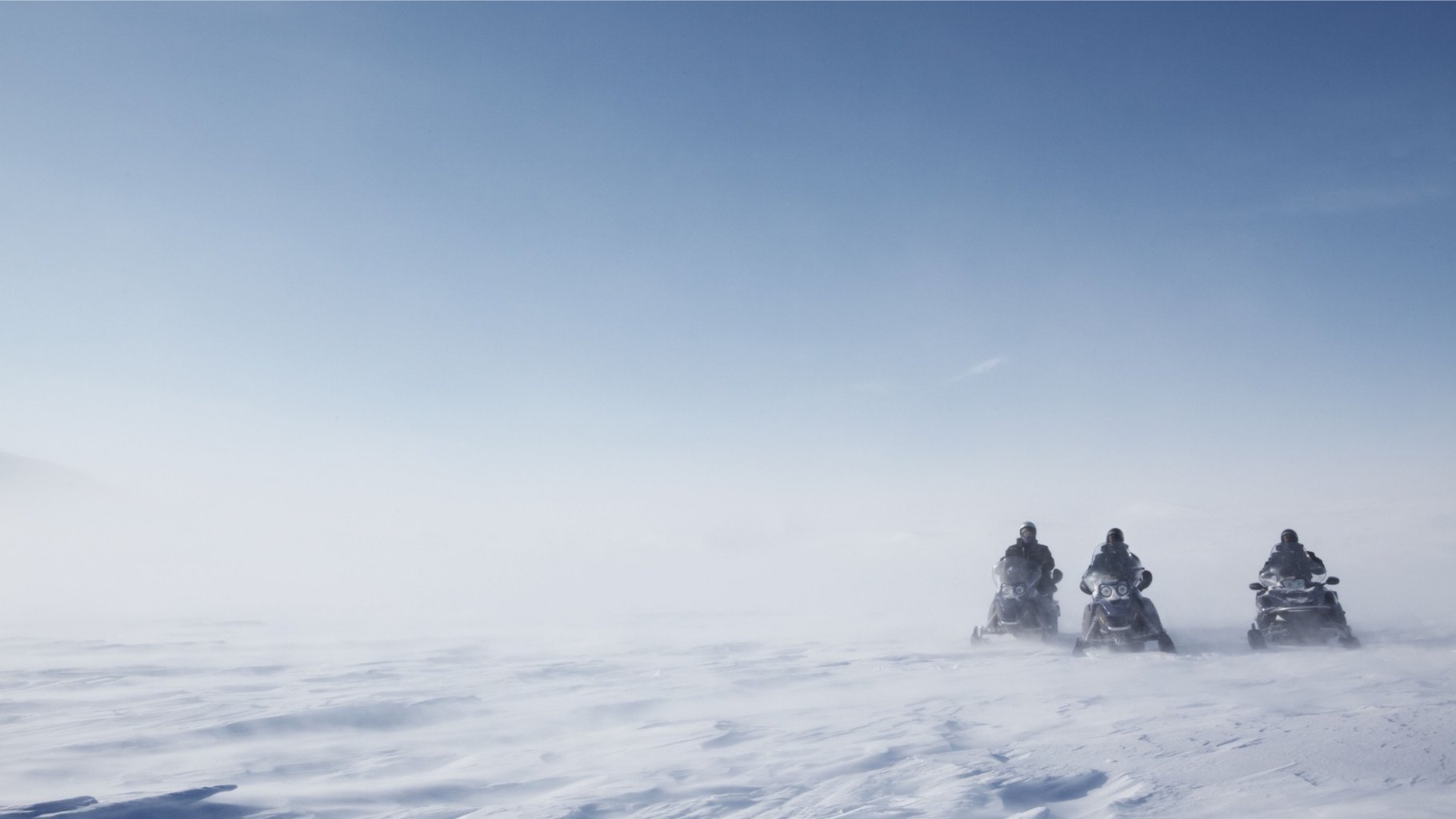 Snowmobile drivers exploring Svalbard.