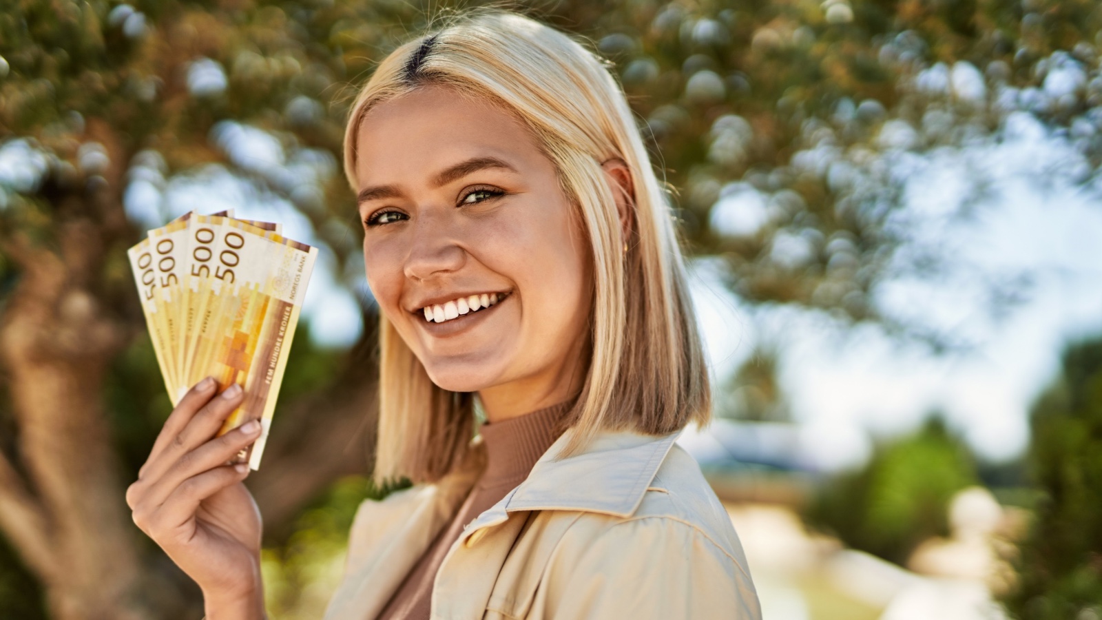 Norwegian woman holding Norway currency.