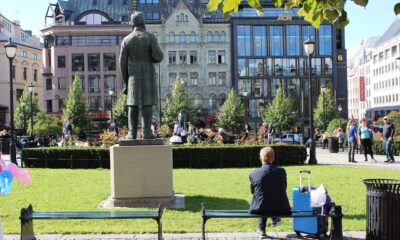 Norwegian sitting on a bench facing away from the camera.