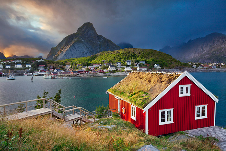 Red cabin in Norway with the Lofoten mountains in the background