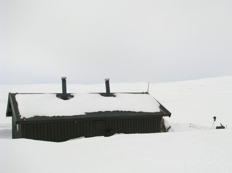 Remote cabin part-buried in snow on the Finnmark plateau in northern Norway.