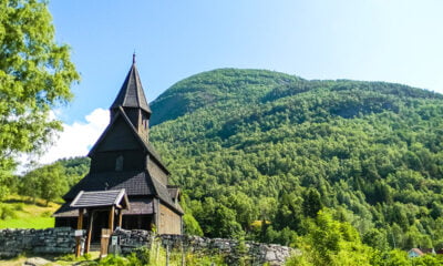 Urnes stave church in a green field in Norway
