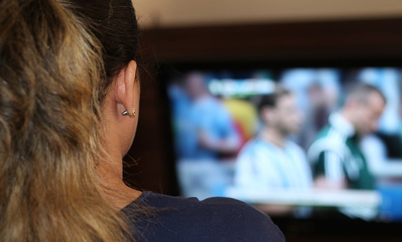 A woman watching football on TV in Norway