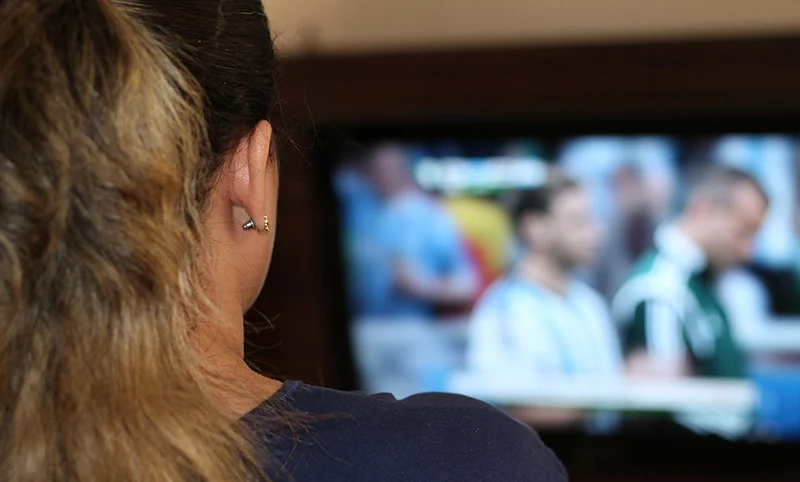 A woman watching football on TV in Norway