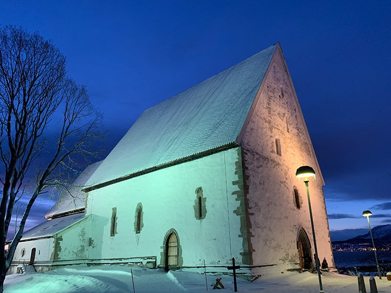 Trondenes Church bathed in stunning polar light. The stone church is in Harstad, Norway