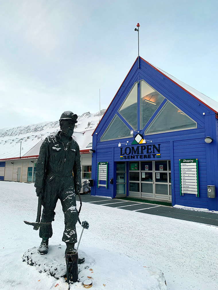 Coal miner sculpture and Lompen shopping centre in Longyearbyen, Svalbard