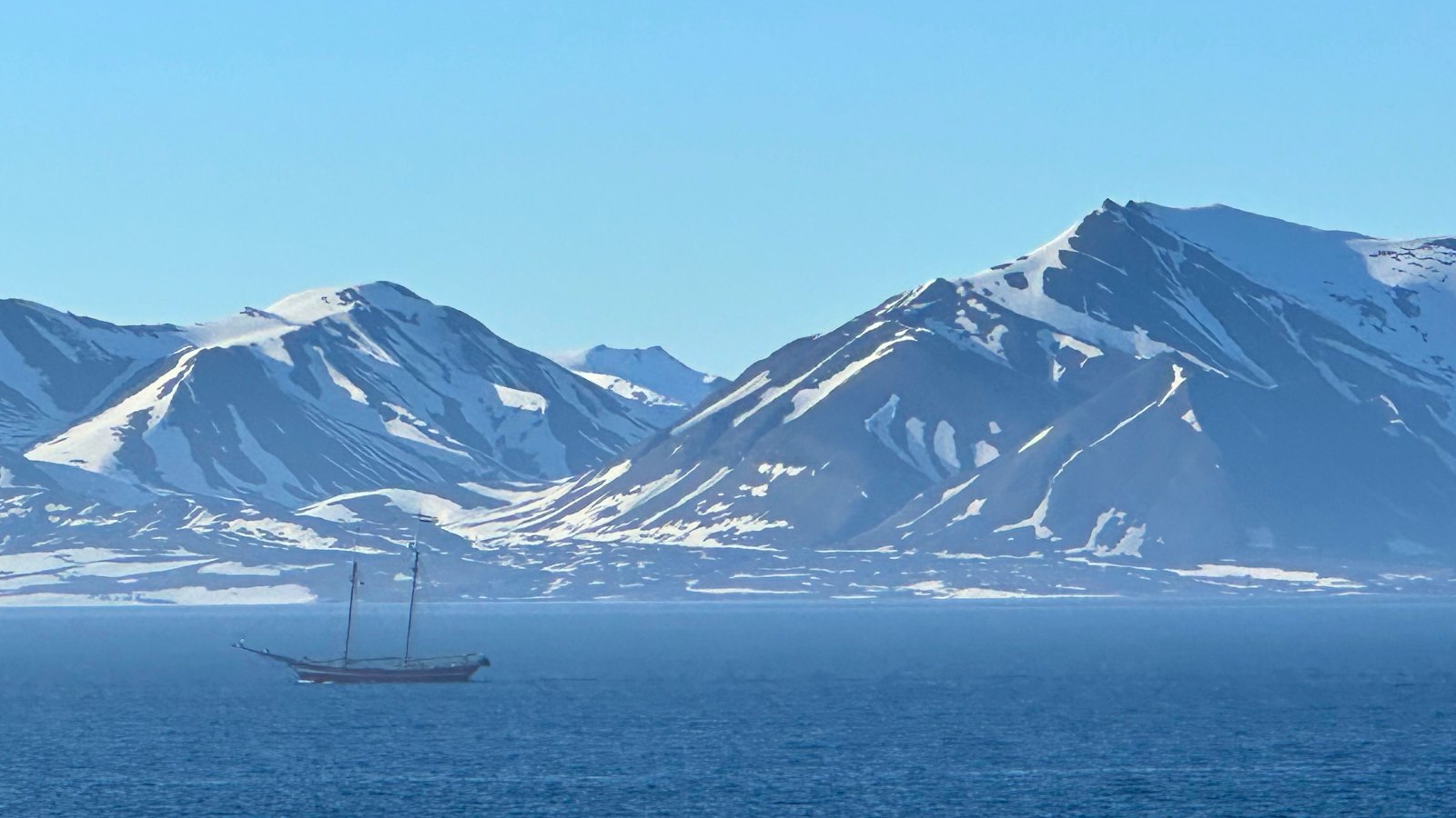 Sailing boat in Svalbard with mountains in the backdrop. Photo: David Nikel.