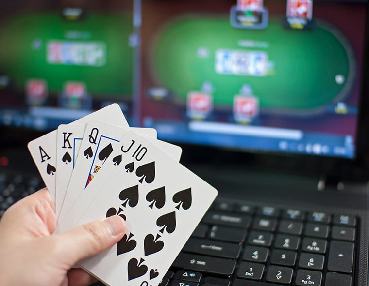 Poker hand with online game in the background.