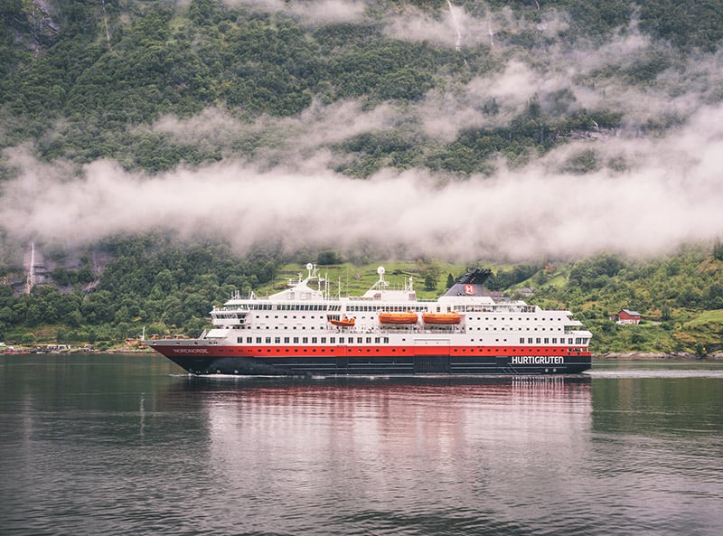 Hurtigruten coastal ferry on a cloudy fjord