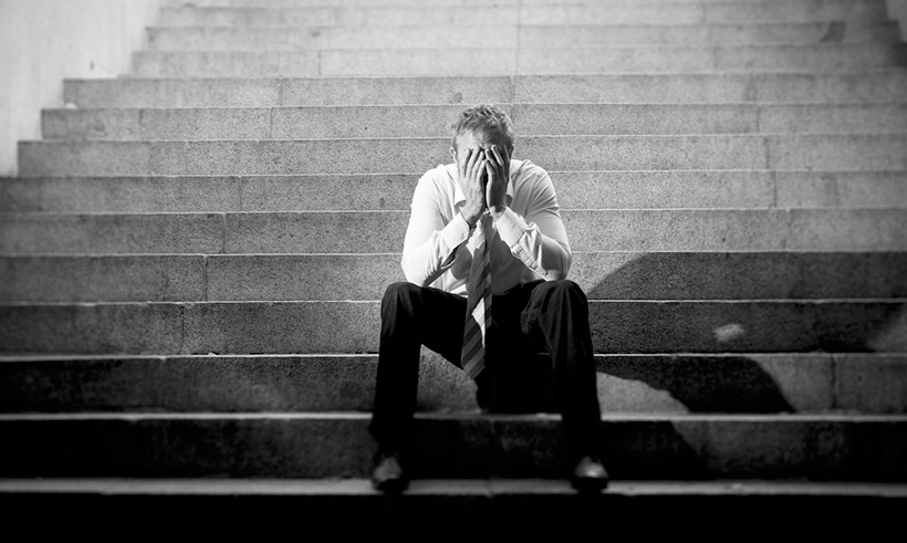 An unemployed person slumped on steps in Oslo, Norway