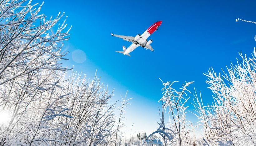 Norwegian 737-800 airline in the sky on a snowy day