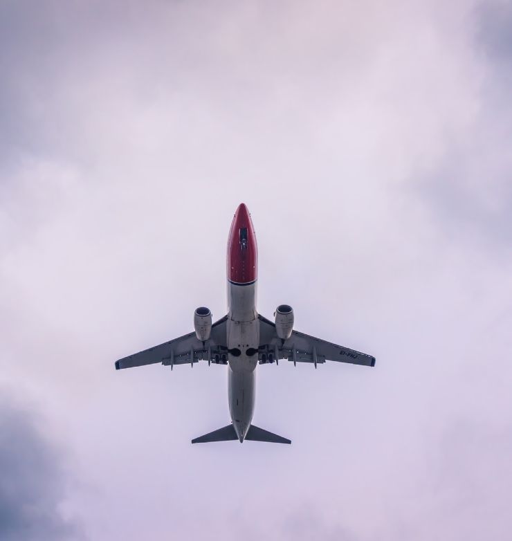 Norwegian Air airplane flying in the sky from below