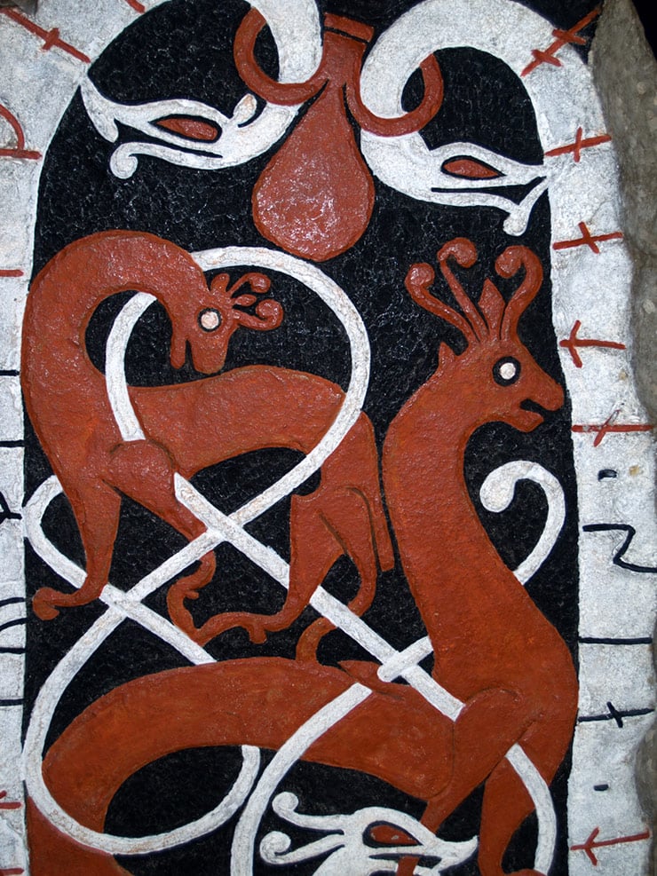 A painted carved Viking stone featuring serpents