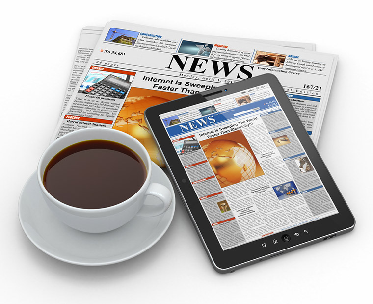 A physical newspaper, online news website, cup of coffee