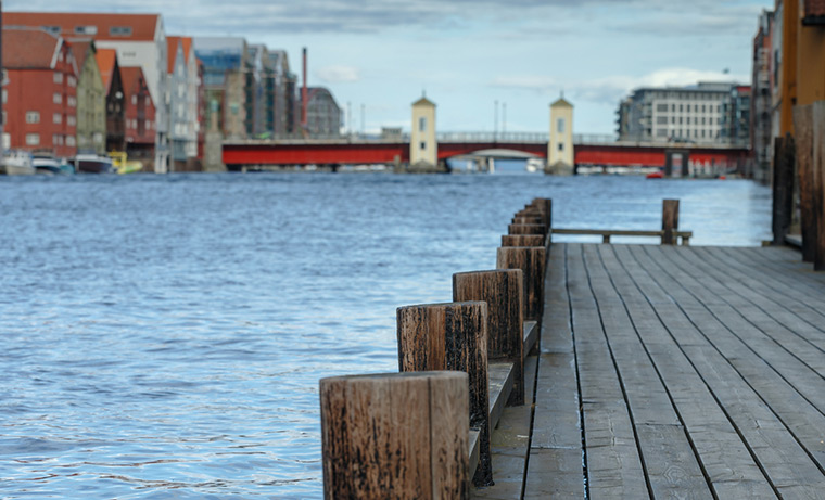 A riverside shot of Trondheim with the bridge in the distance