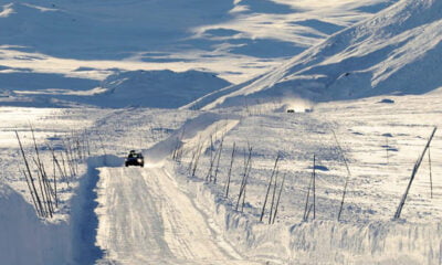 A car driving on the snow-covered Valdresflye mountain road in central Norway
