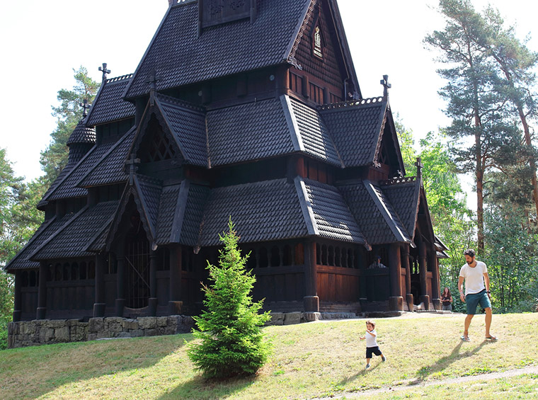 Father and son playing in front of the Gol Stave Church at the Norwegian Museum of Cultural History in Oslo