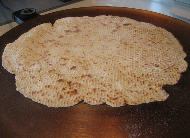 Typical homemade Norwegian lefse on a traditional griddle in Norway