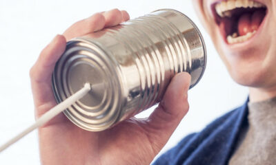 Man speaking Norwegian into a tin can telephone