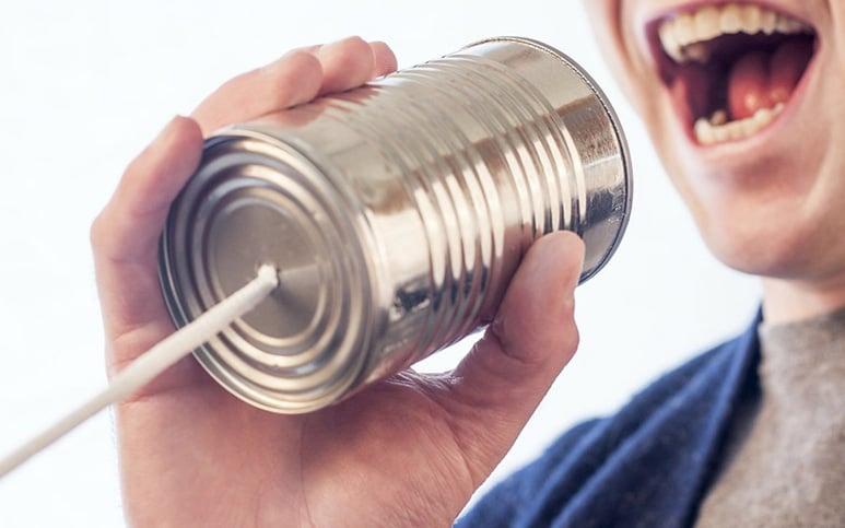 Man speaking Norwegian into a tin can telephone