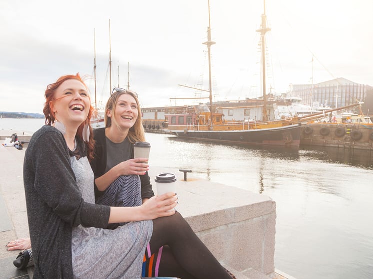 Two Norwegian girls drinking coffee at Oslo harbour in Norway