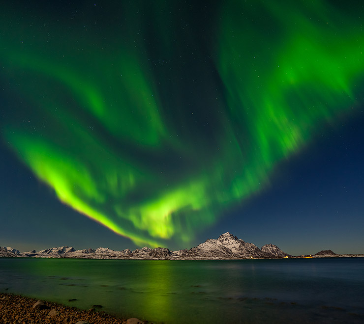 An aurora borealis display in bright green above Senja, northern Norway