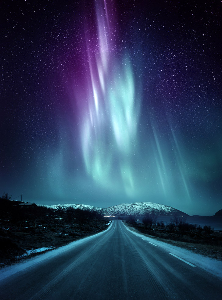 The northern lights above an Arctic road in northern Norway