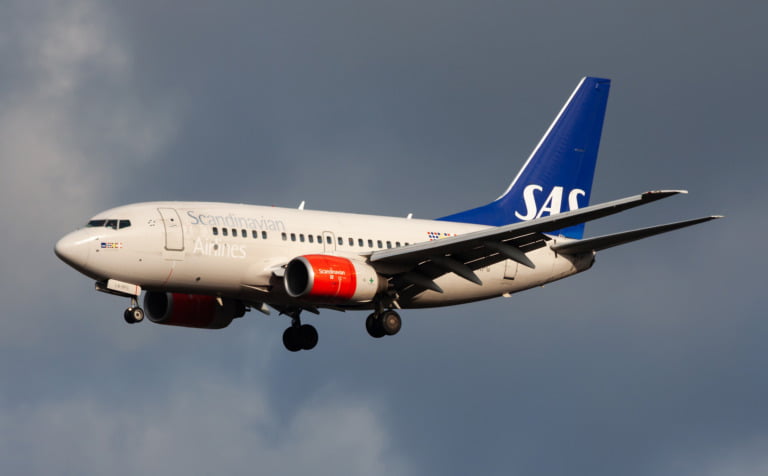 SAS (Scandinavian Airlines) airplane against a stormy sky.