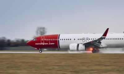 Norwegian Air plane landing on the runway in the rain