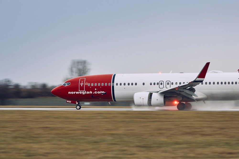 Norwegian Air plane landing on the runway in the rain