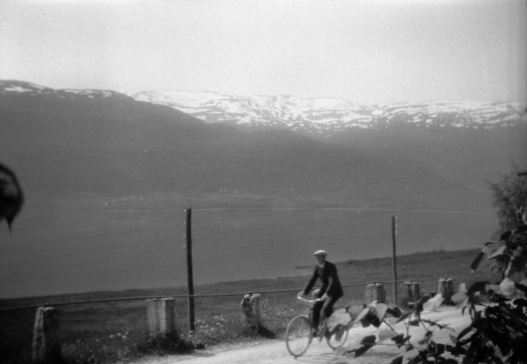 A cyclist in Voss, with the mountains in the background.