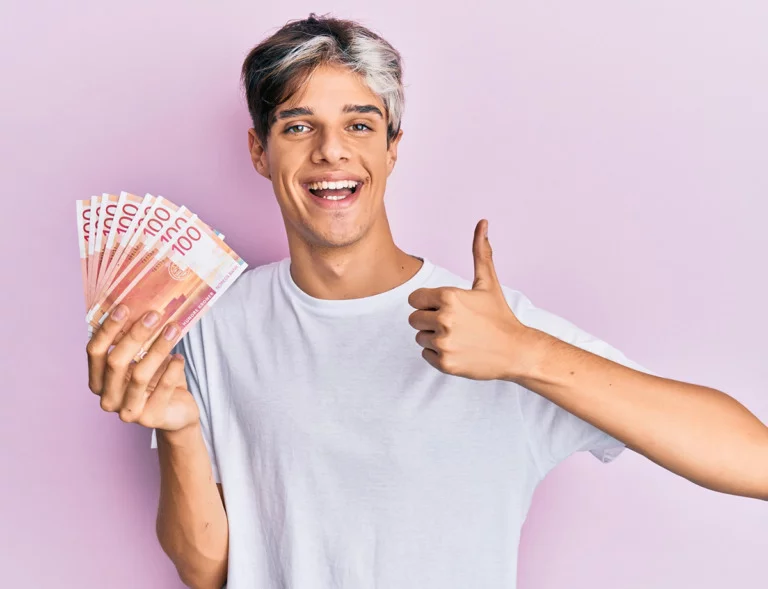 Young man holding Norwegian krone banknotes.