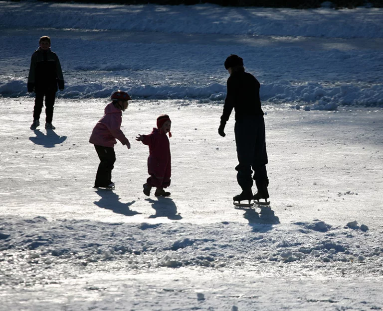 Scandinavian family ice skating in the winter.
