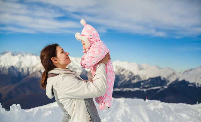 Mother and new baby in Norway with snowy landscape