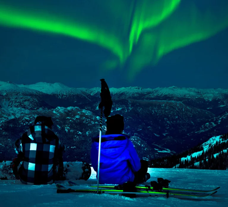Skiers watching the northern lights in Norway