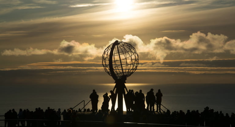 Crowds gather around the globe sculpture at Norway's Nordkapp.