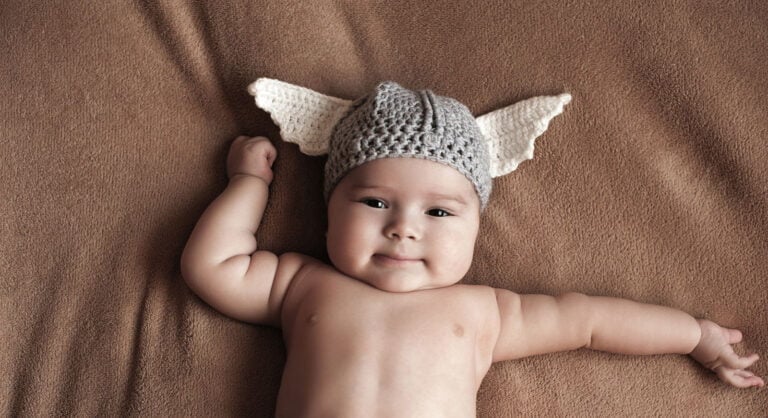 Norwegian baby boy wearing a knitted viking helmet.