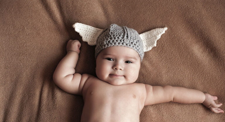 Norwegian baby boy in a knitted viking helmet.