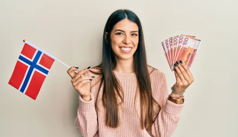 A woman holding Norwegian money and the flag of Norway.