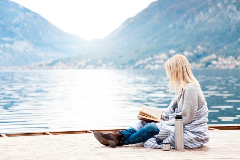 Reader by a fjord in Norway
