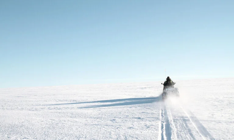 Researcher using a snowscooter on Svalbard