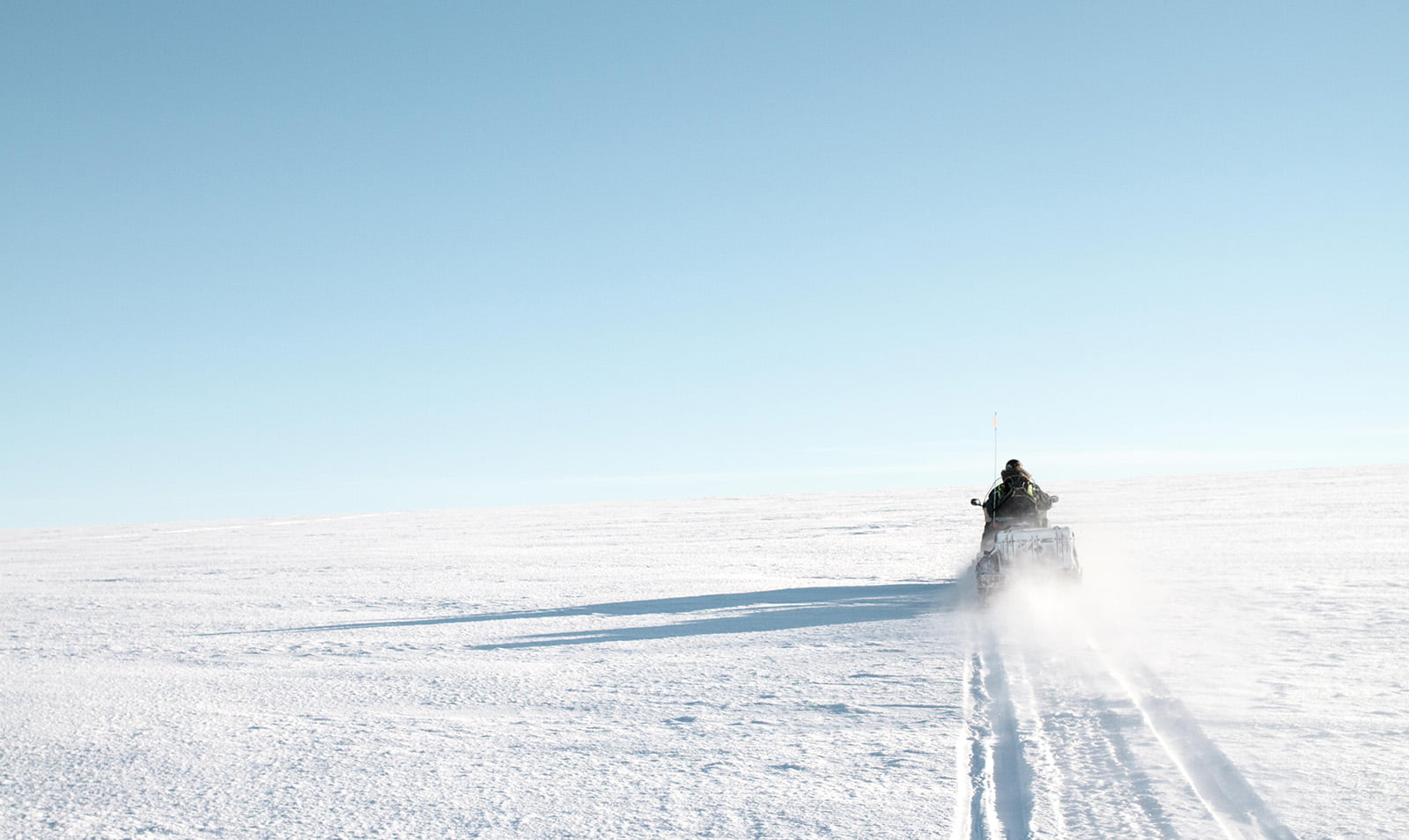 Scientist on a snow scooter in Svalbard