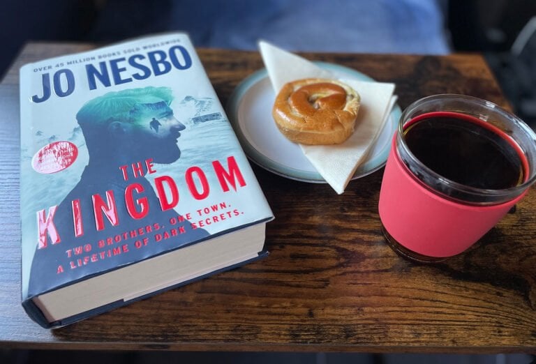 The Kingdom book cover with a cup of coffee
