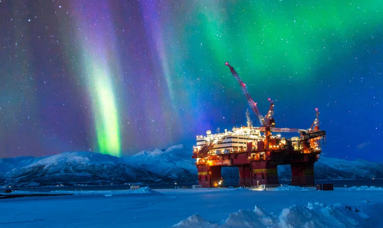 A Norway oil rig with the northern lights in the sky.