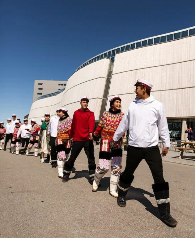 Graduates in national clothing walk next to Katuaq Cultural Centre in Nuuk, Greenland. Photo: Aningaaq R Carlsen / Visit Greenland.