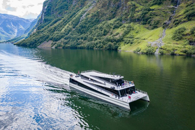 An all-electric sightseeing ferry approaching Flåm on the Aurlandsfjord.