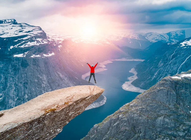 A tall Norwegian jumping at Trolltunga in Norway.